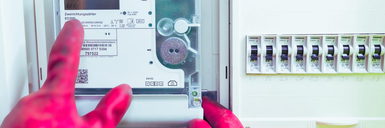 Selbstverbrauchte Strommengen von Sonderkunden Spezialist richtet digitalen Stromzähler ein und trägt dabei Spezialhandschutze